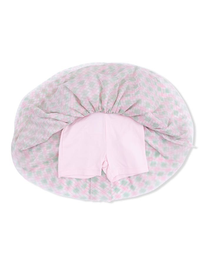 Pink shorts lying on top of a pastel plaid blanket, viewed from above.